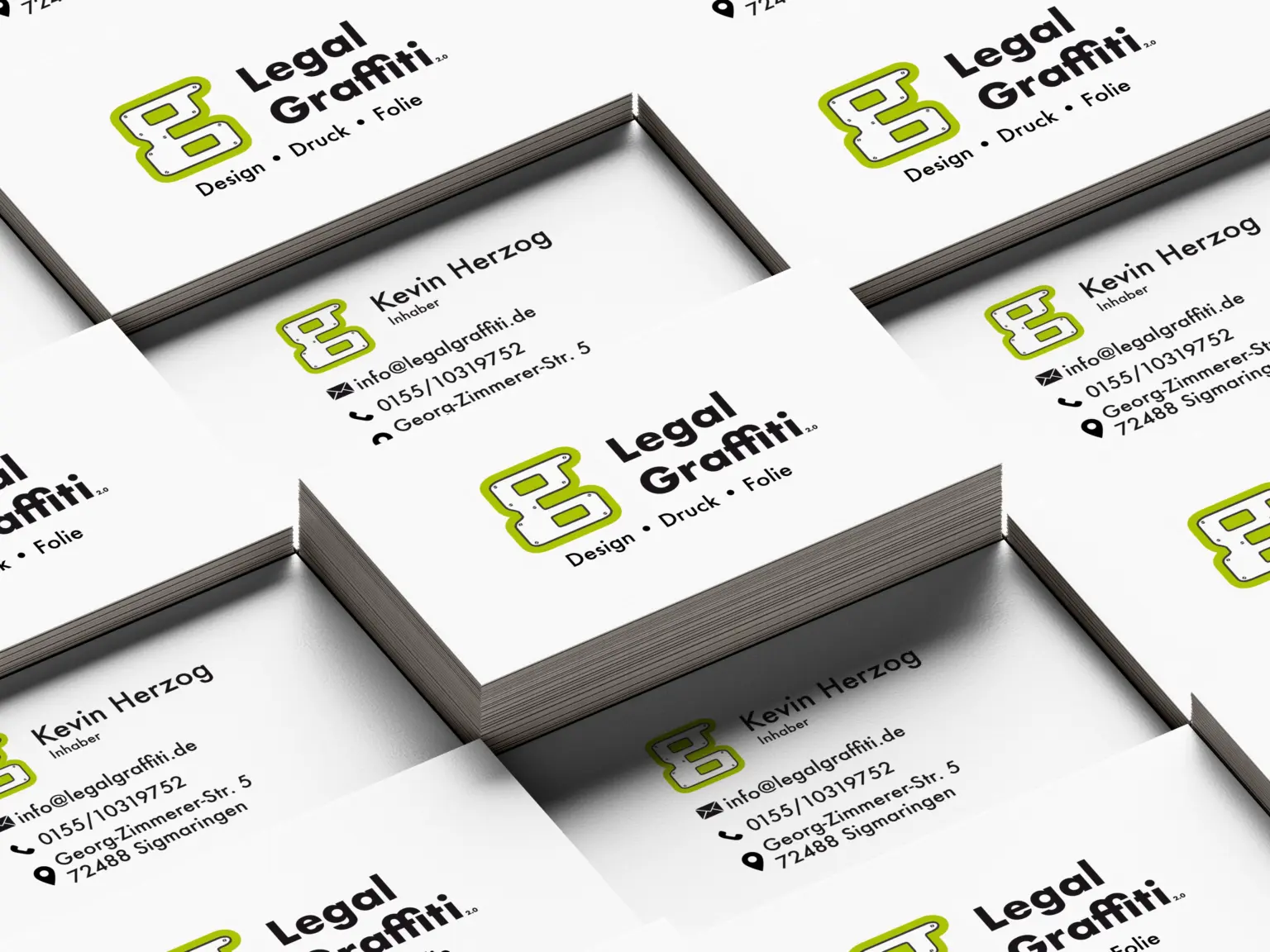 Mehrere Stapel von Visitenkarten die, die Informationen von legal graffiti aus Sigmaringen tragen. Abgebildet sind E-Mail, Telefonnummer und die Adresse.